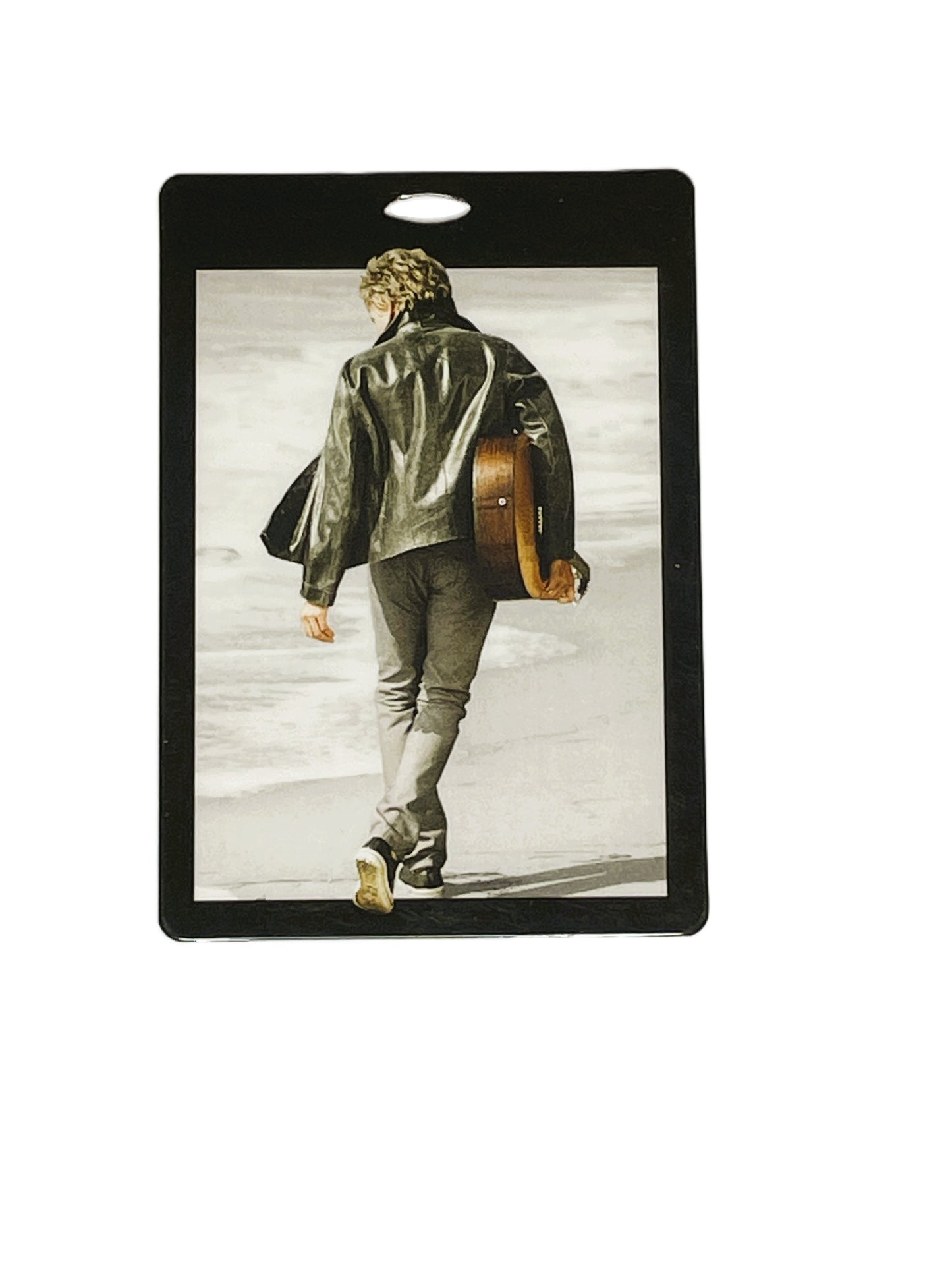 Rod Stewart walking with a guitar on a beach